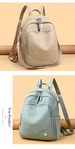 Dettaglio ravvicinato di eleganti zaini da donna in morbida pelle beige e azzurro