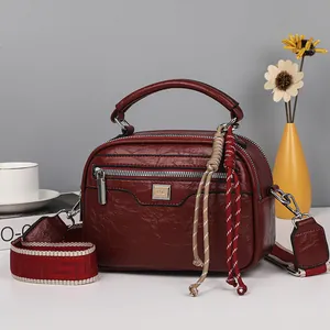Große weinrote Kunstledertasche mit breitem gemustertem Gurt und praktischem Griff