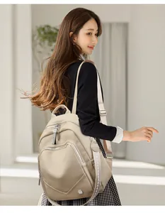 Modella indossa un elegante zaino in morbida pelle beige con spallacci decorati