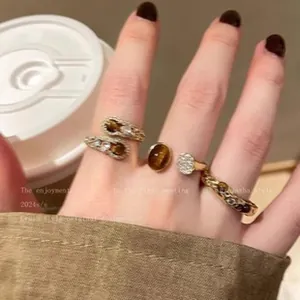 Close-up detail of Maillard style rings with tiger eye stone and zircon