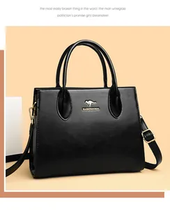 Vista detallada frontal de un elegante bolso tote negro con diseño de logo de canguro dorado.