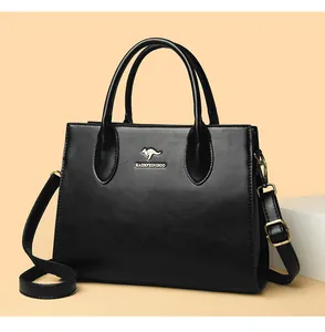 Vista detallada de un elegante bolso tote de cuero negro con logo de canguro dorado