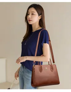 Modelo luciendo un bolso tote de cuero marrón para un estilo de oficina elegante