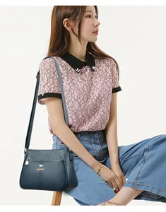 Elegante dunkelblaue Leder-Umhängetasche für Damen mit stilvollem Spitzen-Outfit.