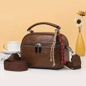 Modische braune strukturierte Mini-Handtasche mit breitem Stickriemen und Quasten