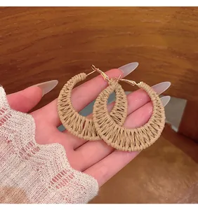 Detailed view of handmade straw woven hoop earrings for beach vacation style.