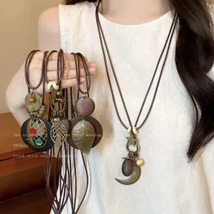 Retro bohemian long necklace set with wooden discs and metal leaf charms for women.
