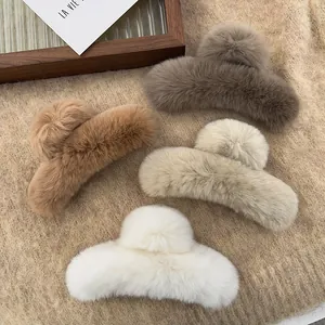 Detailed macro view of four colorful plush faux fur hair claw clips on textured knit background.