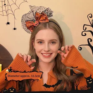 Detail of Halloween bow headband with orange pumpkin, spider web print and polka dot lace