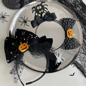Detailed view of Halloween bows and pumpkin spider headbands on a decorative tray