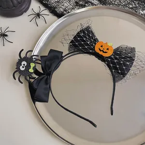 Close-up of Halloween headband with glittery pumpkin and spider decor on a tray.