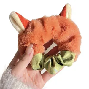 Adorable plush fox ear hair scrunchie made of soft orange fuzzy fabric with green accents