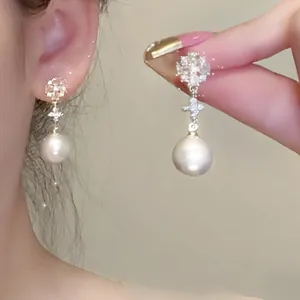 Close-up of elegant French petal pearl earrings with S925 silver needles on model ear.
