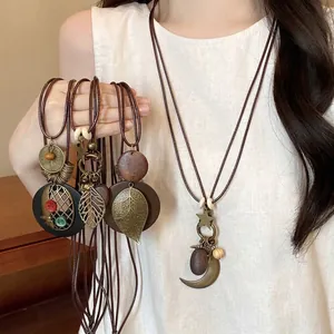 Lange Boho-Halskette im Ethno-Stil mit Holzperlen und Metallanhängern in Blattform