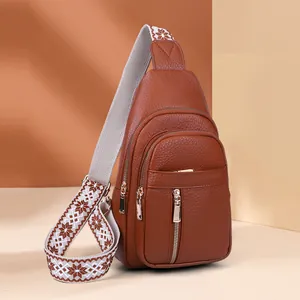Brown pebbled faux leather chest sling bag for women with wide patterned woven strap