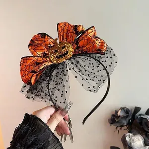 Detailed view of Halloween headband with orange spider web bow and glittery pumpkin