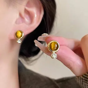 Detailed macro view showing the texture of Maillard style golden acrylic resin earrings.