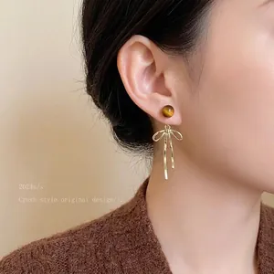 Elegant Maillard style acrylic resin stud earrings with golden bow pendant for women