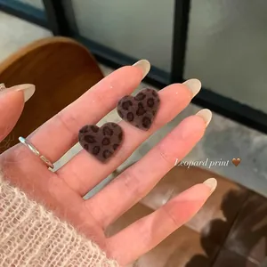 Dettaglio orecchini a cuore con texture floccata e motivo leopardato marrone scuro