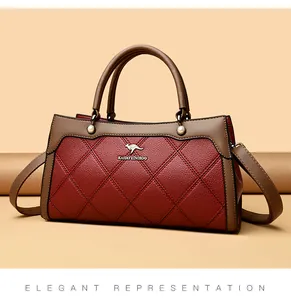 Detail of red quilted leather handbag with elegant brown handles and gold logo.