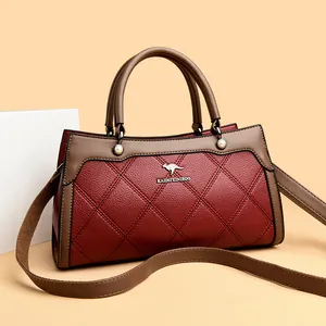 Elegant quilted red and brown women's handbag with kangaroo logo and shoulder strap