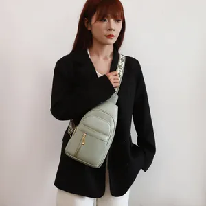 Model wearing a light green textured chest bag with a stylish patterned wide strap