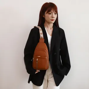 Fashionable brown textured leather chest bag featuring a retro patterned wide strap