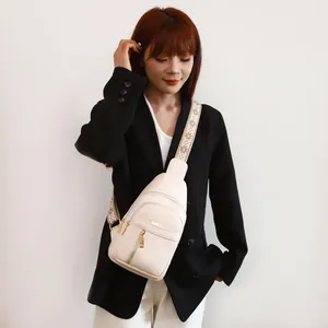 Modern beige faux leather women's chest bag with a wide decorative embroidered strap.