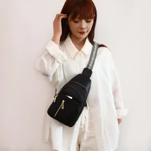 Detail view of black vintage sling bag for women with wide geometric patterned strap