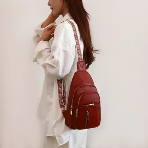 Side view of a dark red litchi grain chest bag with a stylish patterned wide strap