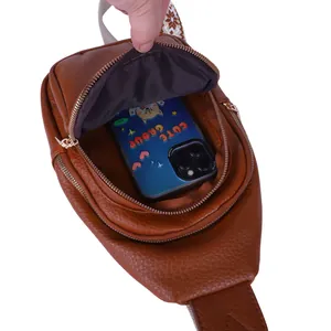 Detailed view of brown faux leather sling bag interior showing phone capacity