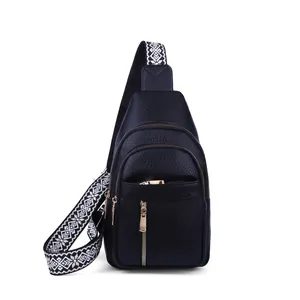 Stylish women's black pebbled leather sling bag with a wide ethnic patterned strap