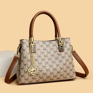 Elegant kangaroo print handbag featuring brown leather trim and polished gold hardware