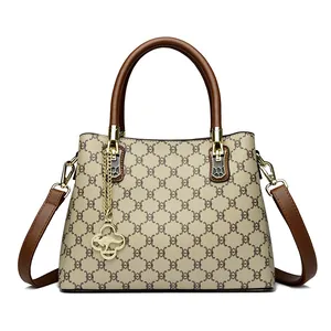 Elegant monogram print handbag with brown leather handles and a gold kangaroo charm