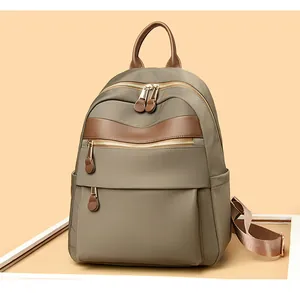 Detailaufnahme eines minimalistischen olivgrünen Damenrucksacks mit braunem Lederbesatz.