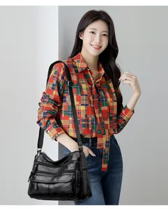 Mannequin asiatique avec un sac à bandoulière noir en cuir lavé à plusieurs poches très chic.