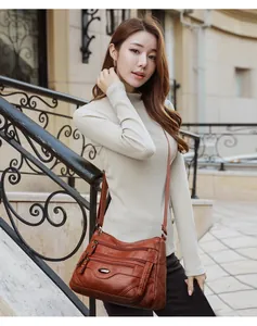 Stylish brown multi-pocket large capacity crossbody shoulder bag shown on model.