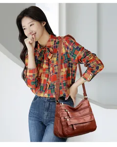 Sac à bandoulière élégant en cuir lavé marron avec plusieurs poches sur un modèle
