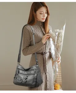 Lifestyle shot of a black multi-pocket soft leather shoulder bag on an Asian model.