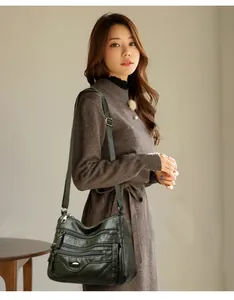 Elegant dark green multi-zipper crossbody shoulder bag for women, lifestyle view