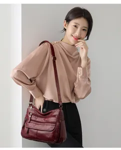 Femme asiatique portant un sac bandoulière bordeaux élégant en cuir lavé à plusieurs poches