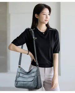 Détail d'un sac bandoulière en cuir lavé souple avec plusieurs poches zippées pour femmes