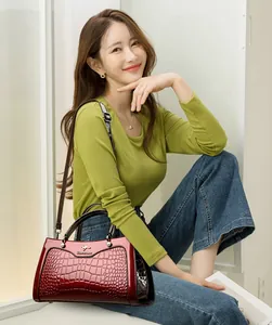 Elegant Asian model posing with a luxury vintage red croc-skin texture handbag for women