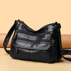 Sac à bandoulière en cuir souple lavé noir avec plusieurs poches zippées