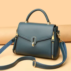 Elegant dark teal pebbled leather handbag featuring gold hardware and a stylish top handle