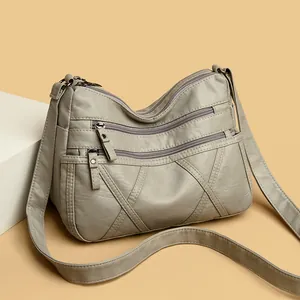 Elegant grey soft leather crossbody bag with multiple zippered pockets for women