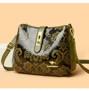 Detail view of retro floral pattern and golden logo on a green crossbody bag for women