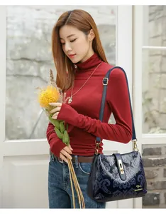 Vintage navy blue embossed floral crossbody bag for women with elegant gold-tone hardware.