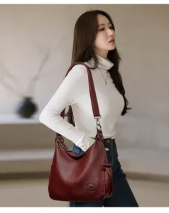 Burgundy pebbled leather hobo shoulder bag styled on a female model in casual wear