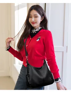 Elegant black pebbled leather crossbody bag with large capacity shown on female model